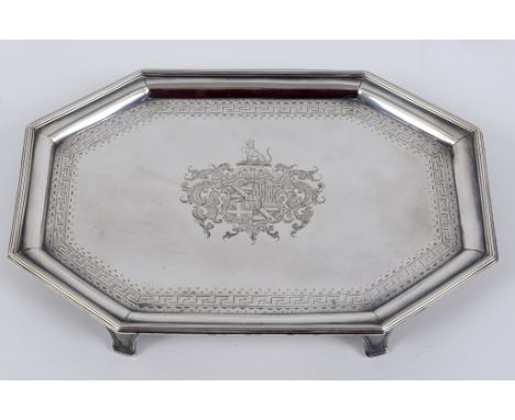 A George III silver tray, decorated a crest and an armorial, with engraved Greek key pattern border and canted corners, Londo