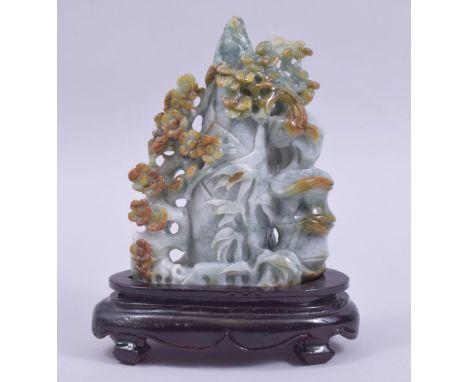 A 20TH CENTURY CHINESE CARVED JADE / JADEITE NATURALISTIC GROUP, mounted to a wooden base, 20cm high.