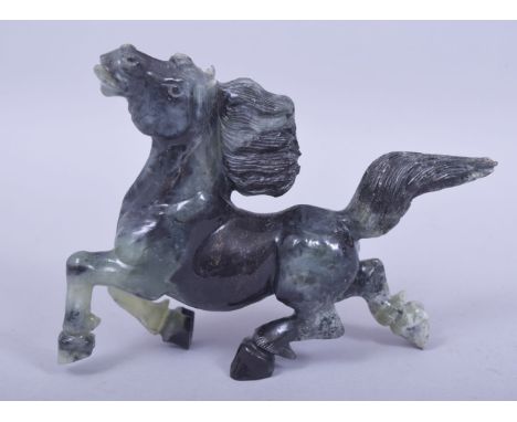 A CARVED JADE / JADEITE MODEL OF A HORSE, 16cm wide.