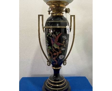 A late Victorian black glass and gilt brass Oil Lamp, of two-handled vase form, the body decorated in coloured enamels with b