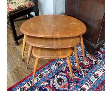 A vintage Ercol nest of three Pebble Tables, largest 65cm x 44cm x 40cm, all needing stripping back and re-polishing.