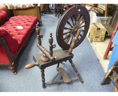 A vintage oak Spinning Wheel, 34in (86.5cm) long, 22in (56cm) wide, 39in (99cm) high.