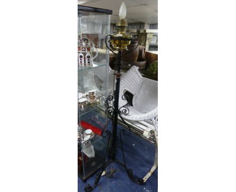 A vintage brass Aladdin Model 12 lamp, stood on later wrought iron stand, 65in (165cm) tall.