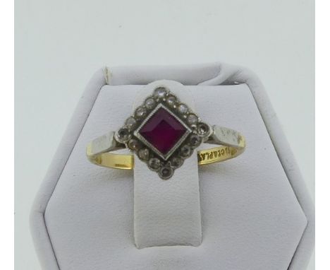 An Art Deco ruby and diamond Dress Ring, the central square cut ruby within a border of sixteen small diamond points, all mil