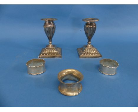 Three silver Napkin Rings, all a/f, 1ozt, together with a pair of silver plated short candlesticks, by Mappin &amp; Webb (5)