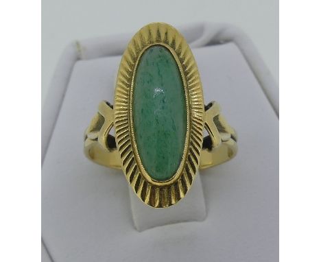 A 14ct yellow gold oval Dress Ring, with a narrow cabchon jade centre within a gold sunburst border, the shank marked 585, Si