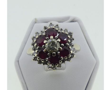 An 18ct white gold, ruby and diamond Cluster Dress Ring, of hexagonal form, the central diamond c. 0.3ct surrounded by six ru