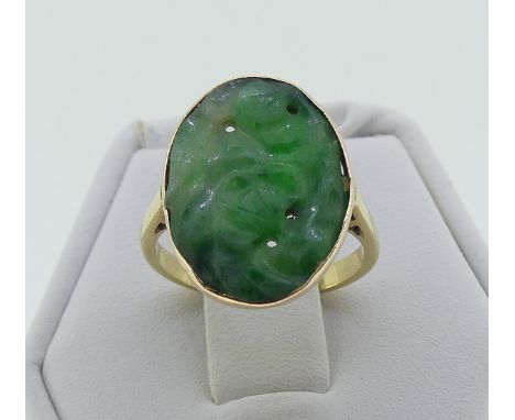 An oval Jade Ring, the oval jade pierced and carved with leaves, in unmarked yellow gold, tested as 18ct, Size I, together wi