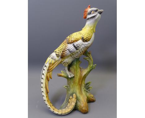 A CONTINENTAL PORCELAIN EXOTIC LONG TAILED BIRD ON A TRUNK, base unmarked, 25cms H