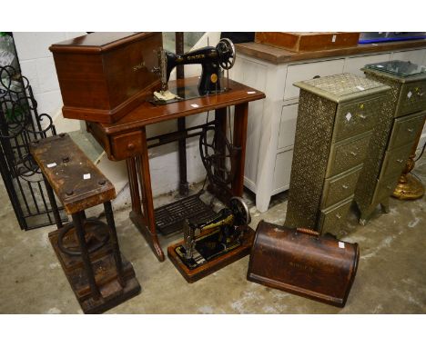 A Singer treadle operated sewing machine together with a table top sewing machine.