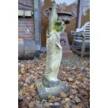 A large reconstituted stone garden ornament modelled as a young lady carrying a pitcher.
