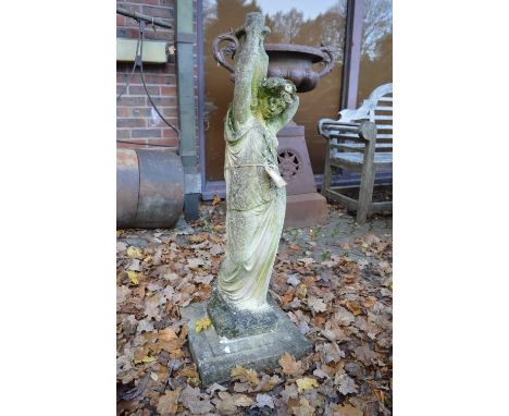 A large reconstituted stone garden ornament modelled as a young lady carrying a pitcher.