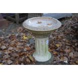 A reconstituted stone circular bird bath.
