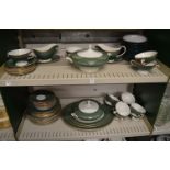 A dinner service decorated with green and gilt bands.