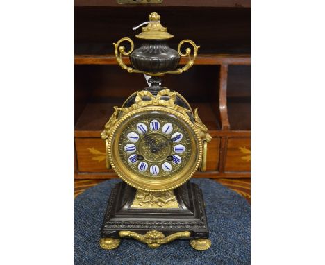 A good French bronze and gilt bronze mantel clock with urn shape finial and enamel numerals.