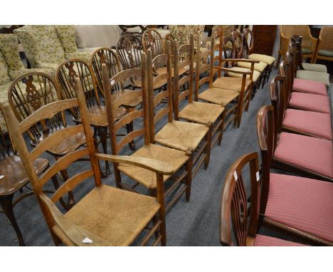 A set of six ladder back and rush seated dining chairs, two with arms.