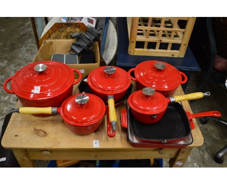 A quantity of red enamel cast iron cookware.