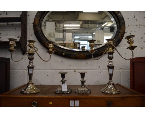 A pair of Sheffield plate twin branch, three light candelabra together with a smaller pair of candlesticks.