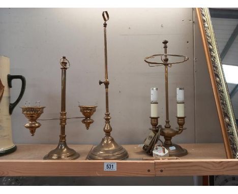 A brass table lamp, candle lamp and one other.