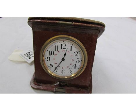 A vintage travel clock in leather case, in working order.