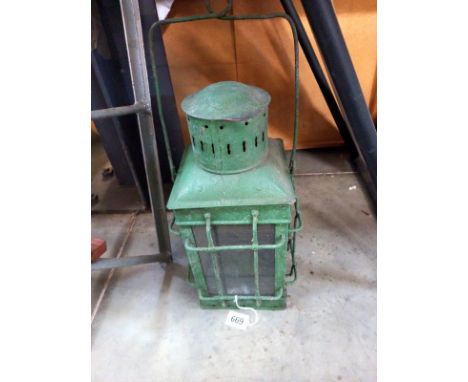 A green painted metal candle lantern.
