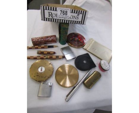 A tray of vintage compacts and lighters.