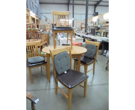 A light oak extending dining table and four chairs.