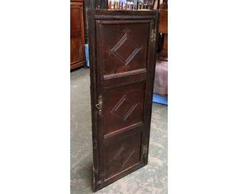 An oak corner cupboard, formed from the front of a three panel coffer, 56x131cm 