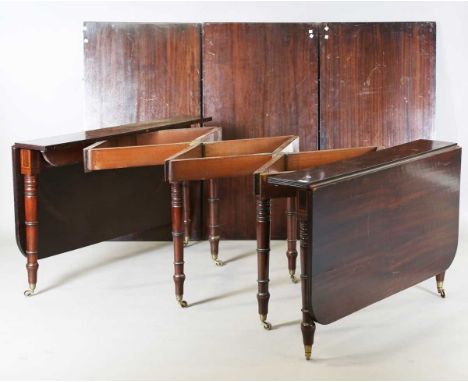 A Regency mahogany concertina-action extending dining table, in the manner of Wilkinson of Moorfields, London, the top with t