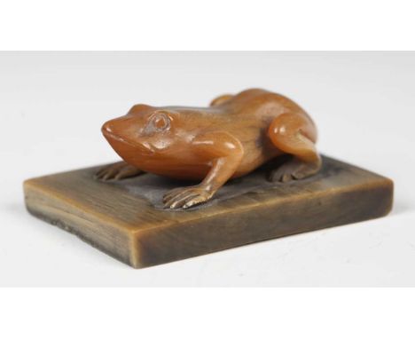 A 19th century Chinese carved rhinoceros horn model of a frog, mounted on a horn rectangular base, length 6cm. Note: as this 
