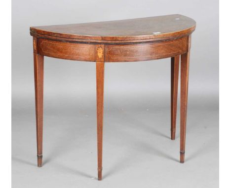 A George III mahogany demi-lune fold-over card table, the frieze inlaid with fan paterae, height 73cm, width 91cm, depth 46cm