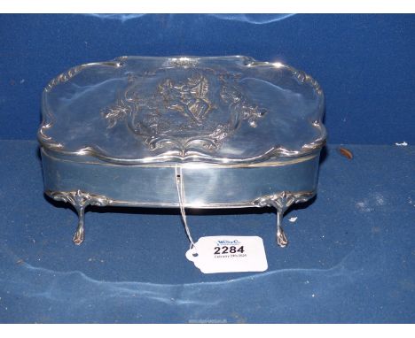 An ornate Silver jewellery Casket with scroll edges and embellished with a panel of a young girl on a swing, on paw feet and 