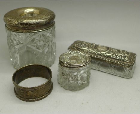 A silver topped hair tidy, a silver topped trinket box, a silver topped jar and a napkin ring