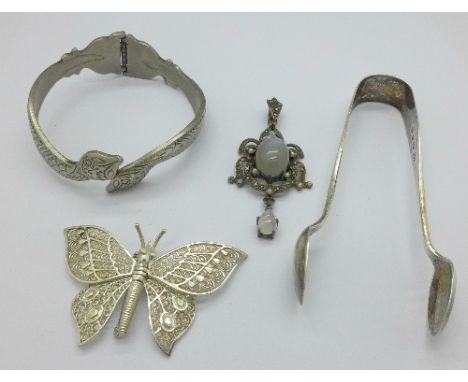 A silver and moonstone pendant, a silver butterfly brooch, a bangle and a pair of Victorian silver sugar bows