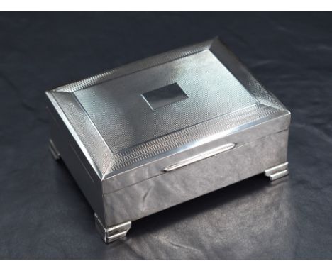 An Elizabeth II silver cigarette box, of hinged rectangular form with engine turned decoration and central vacant rectangular