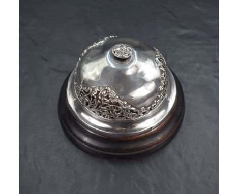 An early 20th century silver mounted mechanical desk bell, having embossed and pierced floral decoration, with an embossed sc