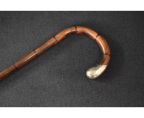 A late Victorian silver mounted walking stick, the bamboo cane with curved handle finishing with a silver mount, having rubbe