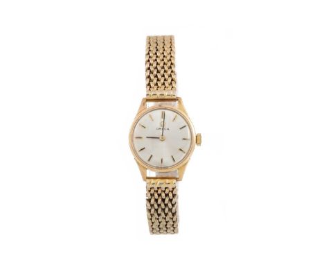 OMEGA NINE CARAT GOLD MANUAL WIND WRIST WATCH the round dial with baton hour markers, 18mm case, on an unmarked bracelet, lac