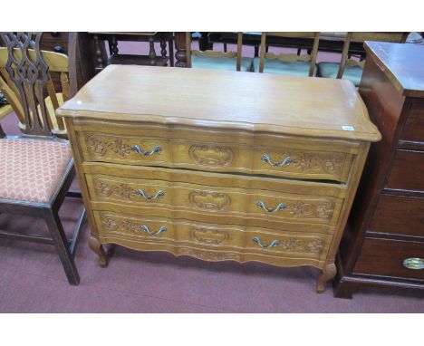 A Continental Oak commode, with a shaped moulded edge, 3 long drawers with C scroll decoration on small carved cabriole legs,