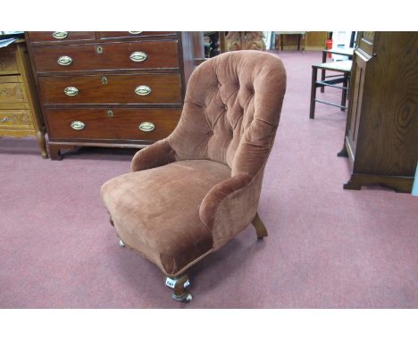 A XIX Century Walnut Nursing Chair, on porcelain castors, upholstered in a rust red button back drylon.