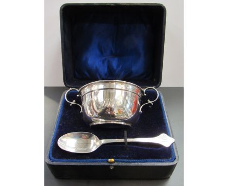 A silver twin handled bowl and associated silver spoon monogrammed 108g