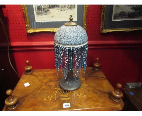 A bronzed base table lamp with blue mottled and tasseled shade 
