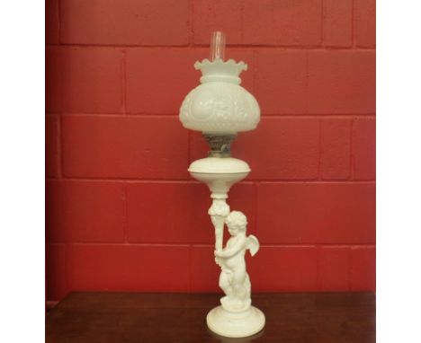 A Victorian oil lamp with opaque shade, ceramic cherub base