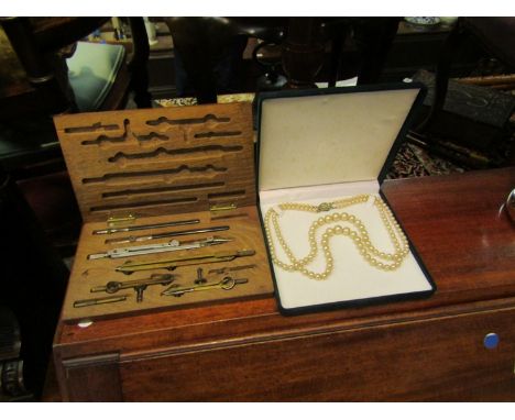 A costume pearl necklace and a geometry set 