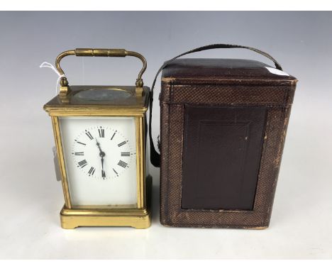 A late 19th / early 20th Century brass cased carriage clock, having a Corniche case with bevelled glass, white enamelled dial