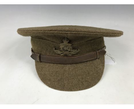 A British Army serge peaked cap, of other ranks' quality, bearing Royal Artillery cap badge, manufactured by Dunn &amp; Co