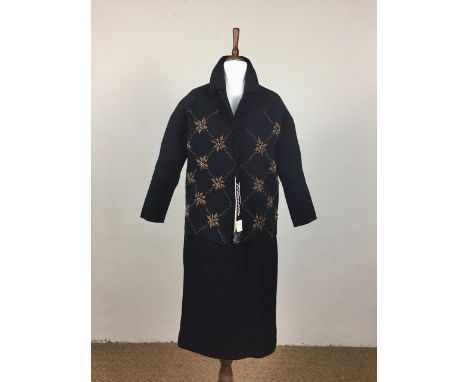 An early 1960s black knitted wool wiggle suit by Tricoville, comprising button-fronted jacket and skirt, the former having a 