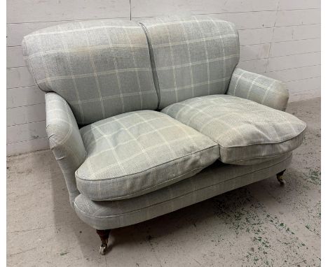 A two seater sofa upholstered in a pale blue check 