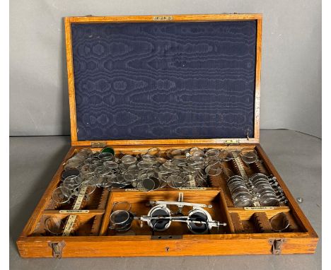 A vintage opticians set with glasses and lenses in a fitted pine box 