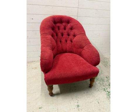 A red upholstered button back bedroom chair on turned legs 
